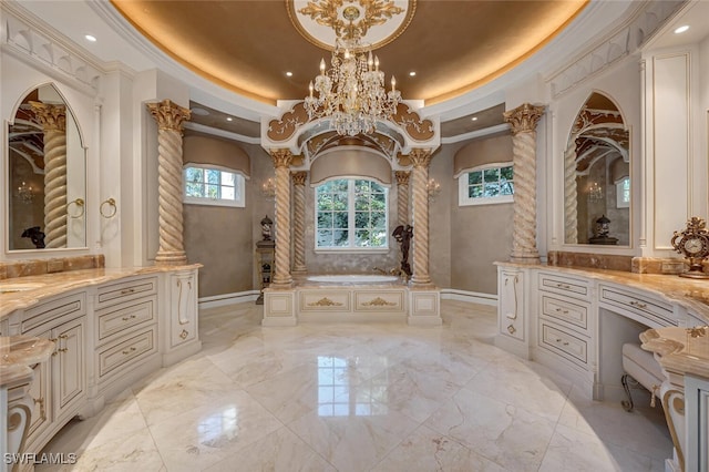 bathroom with decorative columns, a bath, vanity, and crown molding