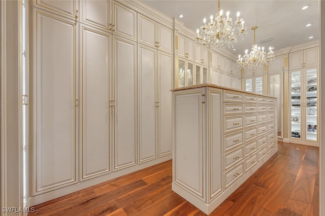 walk in closet featuring hardwood / wood-style flooring and a notable chandelier