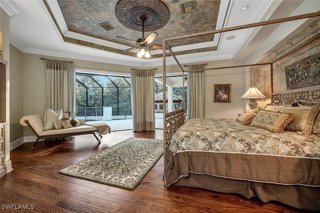 bedroom with ornamental molding, a tray ceiling, ceiling fan, and dark wood-type flooring