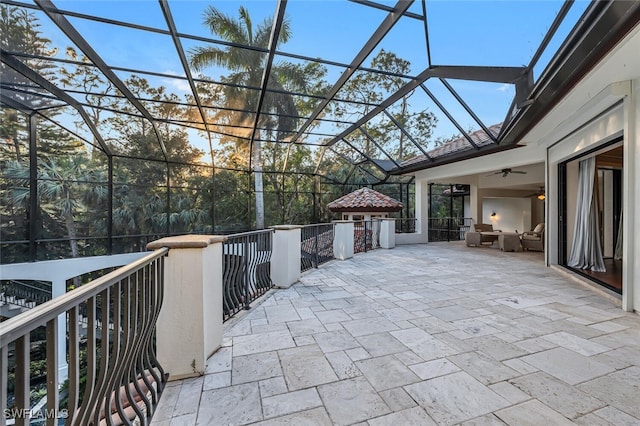 view of patio featuring ceiling fan and a lanai