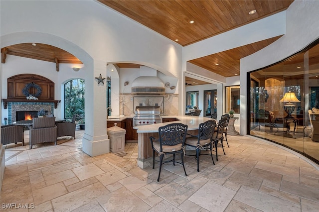 dining space featuring wood ceiling, decorative columns, and sink