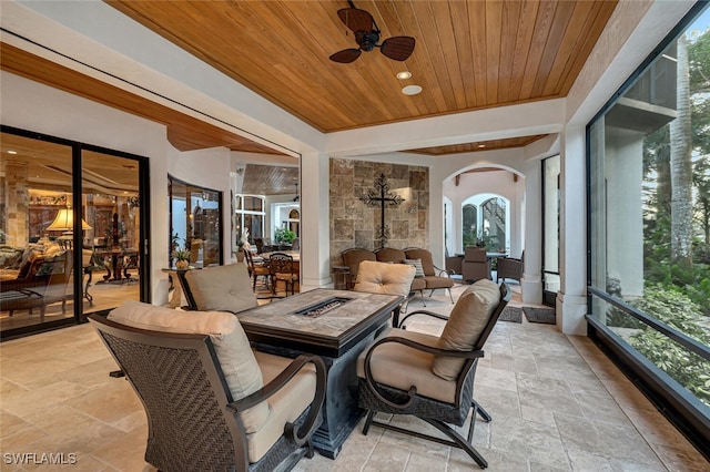 sunroom / solarium with wooden ceiling, ceiling fan, and plenty of natural light