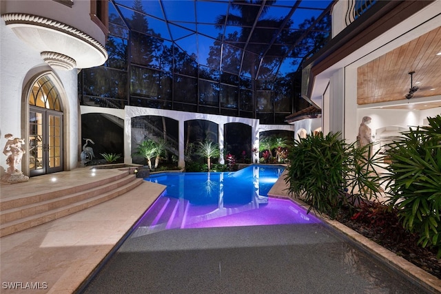 view of swimming pool featuring glass enclosure, a patio area, and french doors