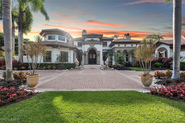 mediterranean / spanish-style home featuring a lawn