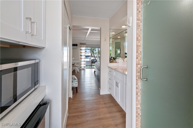 corridor featuring baseboards and light wood finished floors