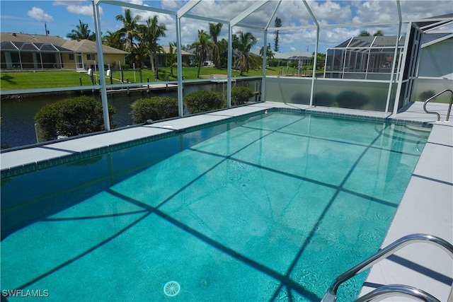 view of pool with a lanai, a water view, and a yard