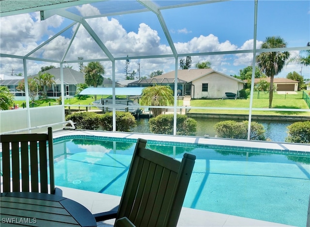 view of swimming pool with a yard, glass enclosure, and a water view