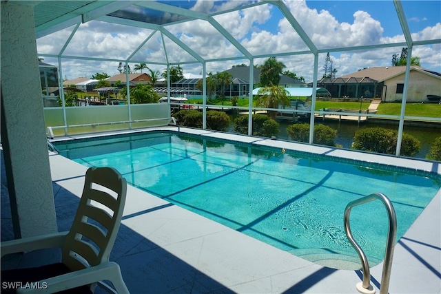 view of pool with glass enclosure, a water view, and a patio area