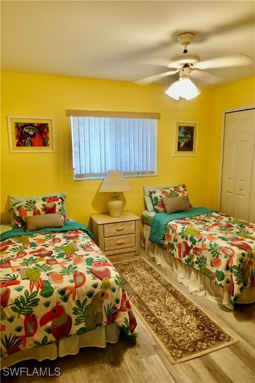 bedroom featuring wood-type flooring, ceiling fan, and a closet