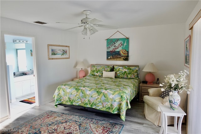 bedroom with ceiling fan, hardwood / wood-style floors, and ensuite bathroom