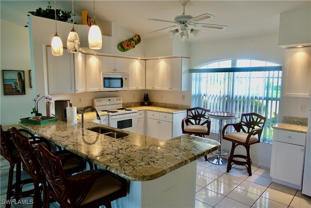 kitchen with kitchen peninsula, white appliances, white cabinetry, and hanging light fixtures