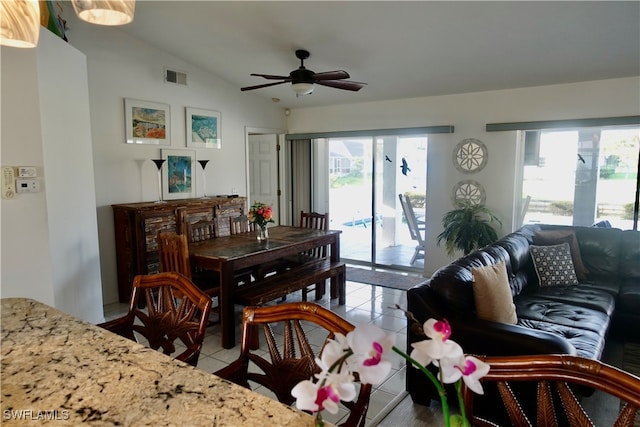 dining space with vaulted ceiling, ceiling fan, and light tile patterned floors