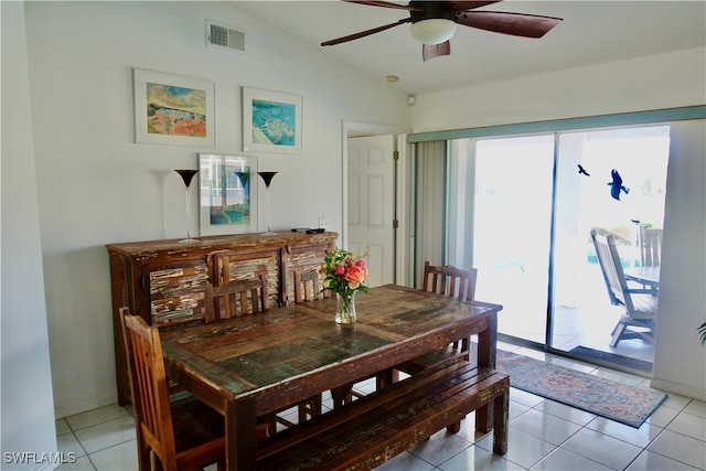 tiled dining space with ceiling fan and lofted ceiling