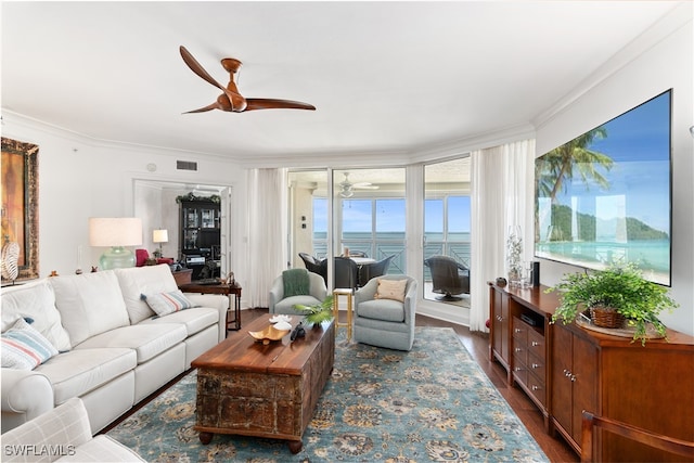 living room featuring crown molding, ceiling fan, a water view, and dark hardwood / wood-style flooring