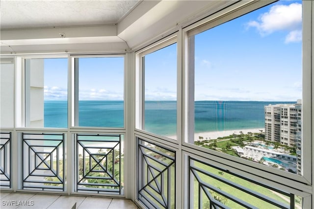 unfurnished sunroom featuring a water view