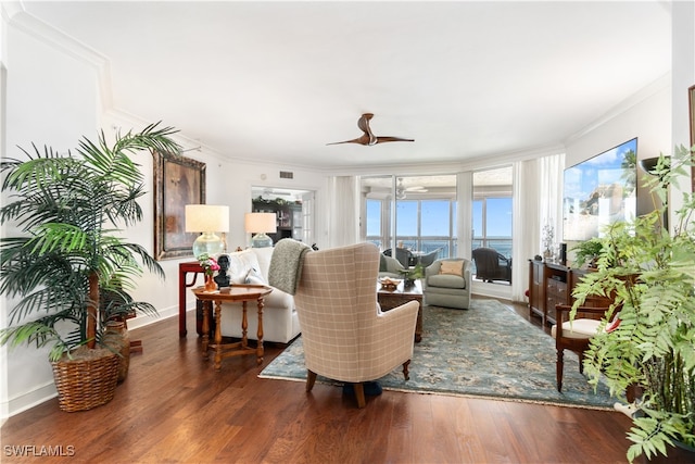 living room with crown molding, dark hardwood / wood-style floors, and ceiling fan