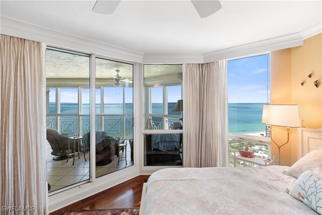 bedroom featuring a water view and multiple windows