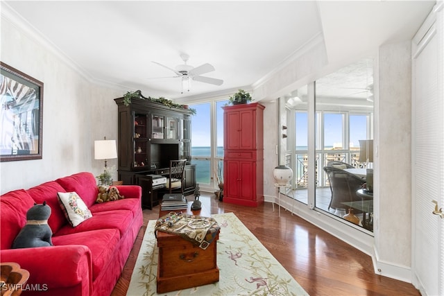 living room with dark wood-type flooring, ceiling fan, ornamental molding, and plenty of natural light