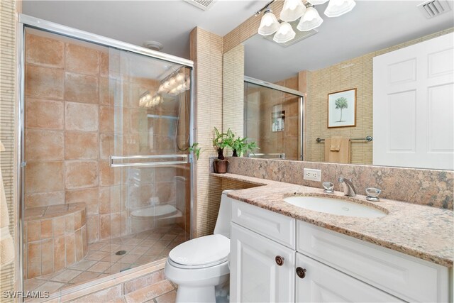 bathroom featuring vanity, toilet, a shower with shower door, and tile patterned flooring