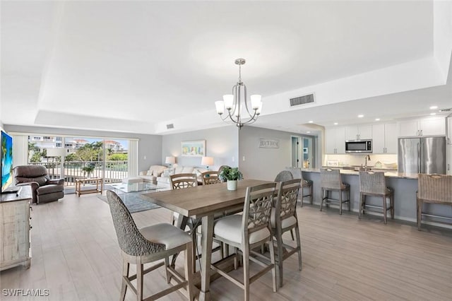 1036 S Collier Blvd Unit 101, Marco Island, FL 34145 - dining area with a tray ceiling, a chandelier, light wood-style flooring, and recessed lighting