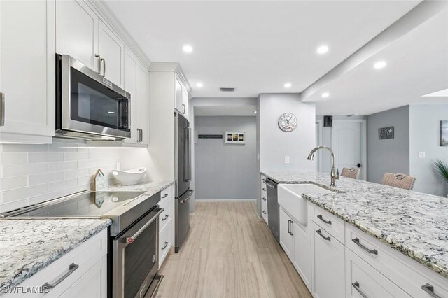 1036 S Collier Blvd Unit 101, Marco Island, FL 34145 - kitchen featuring stainless steel appliances, a sink, white cabinetry, tasteful backsplash, and recessed lighting