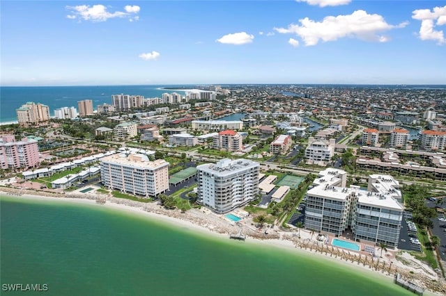 birds eye view of property with a water view and a beach view