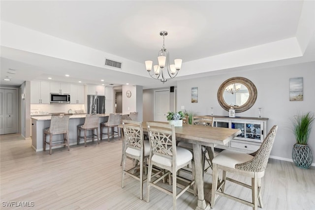 dining room featuring a notable chandelier and light hardwood / wood-style flooring