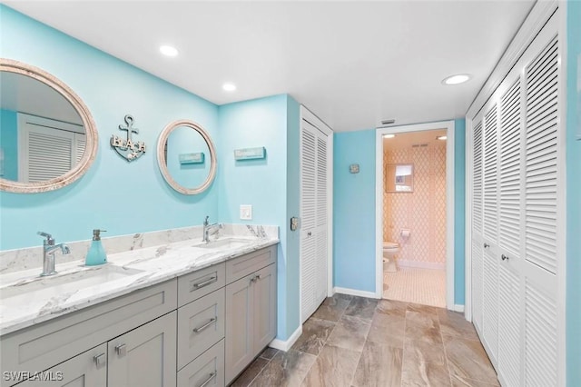 1036 S Collier Blvd Unit 101, Marco Island, FL 34145 - bathroom with a closet, toilet, baseboards, double vanity, and recessed lighting
