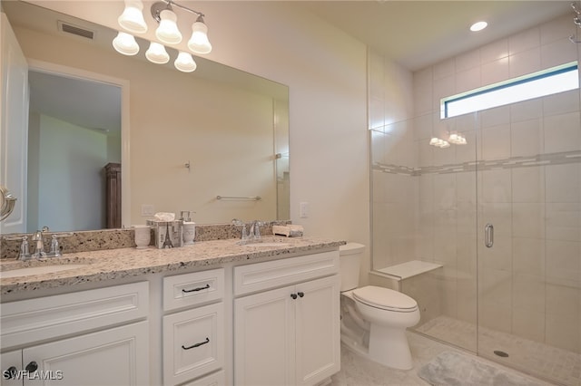 bathroom featuring vanity, toilet, and a shower with shower door