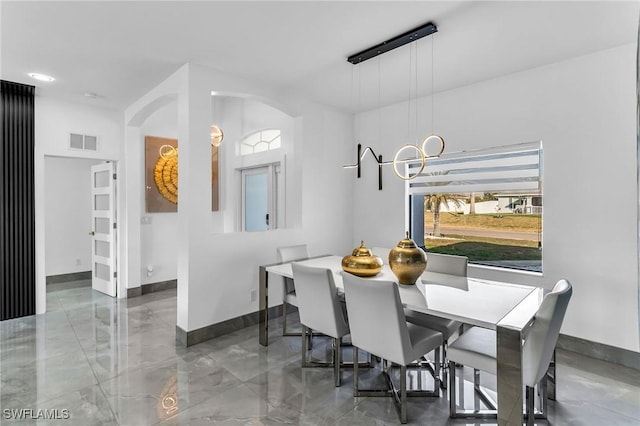 dining area featuring plenty of natural light and a notable chandelier