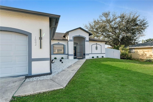 entrance to property with a garage and a lawn