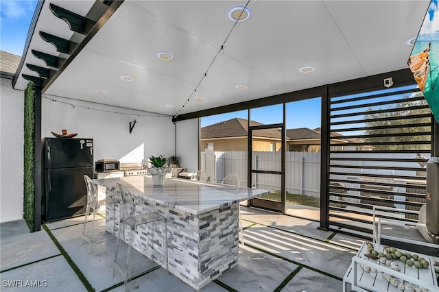 view of patio with an outdoor kitchen and a bar