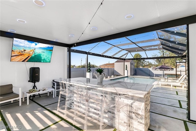 view of patio featuring glass enclosure, a shed, and an outdoor bar