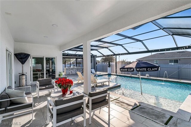 view of pool featuring glass enclosure, a patio area, and pool water feature