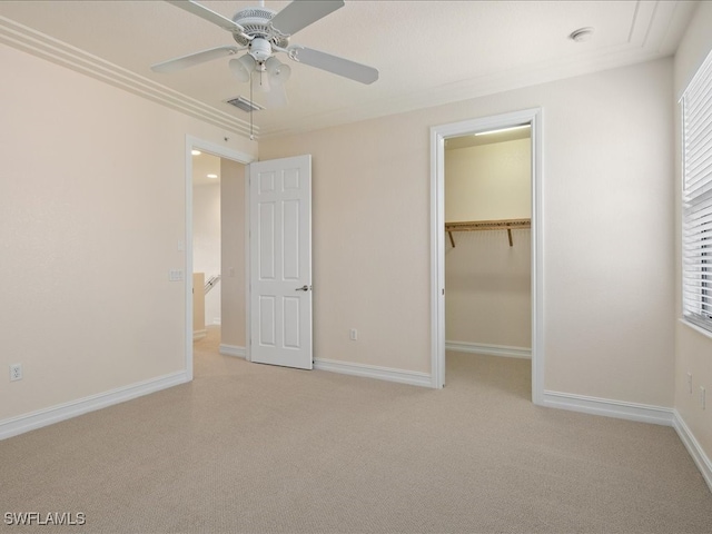 unfurnished bedroom featuring ceiling fan, a closet, and a spacious closet