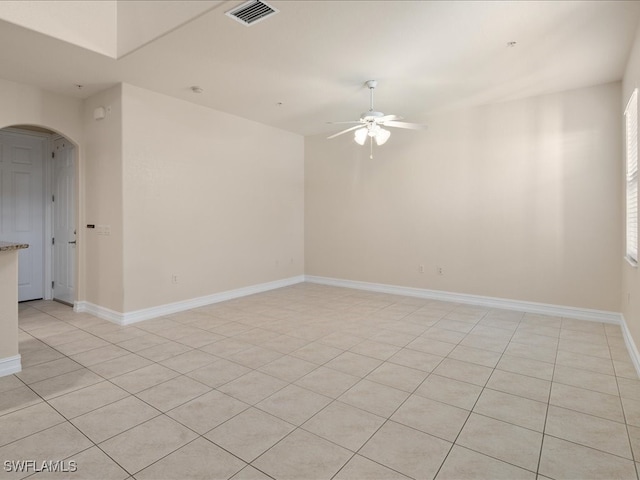 tiled empty room featuring ceiling fan