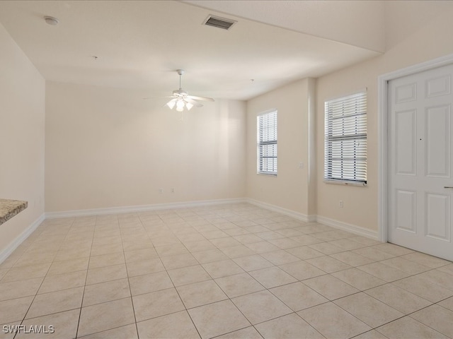 spare room with ceiling fan and light tile patterned floors