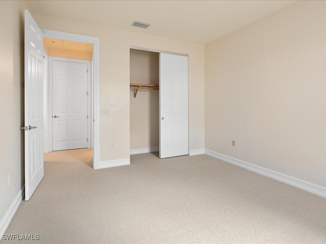 unfurnished bedroom with light carpet and a closet