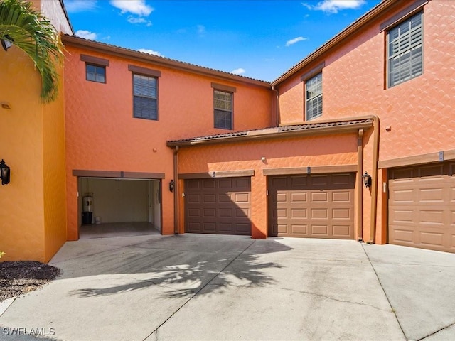 9098 Capistrano St S Unit 7103, Naples, FL 34113 - view of property with stucco siding, a garage, and driveway