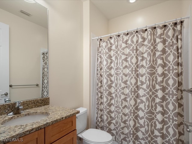 bathroom featuring a shower with shower curtain, vanity, and toilet