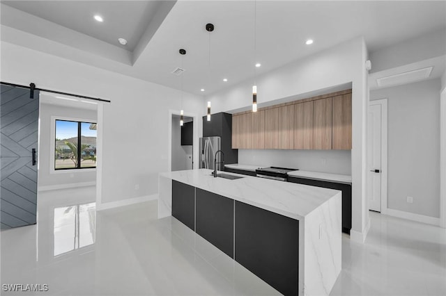 kitchen featuring a spacious island, a barn door, a sink, modern cabinets, and stainless steel fridge