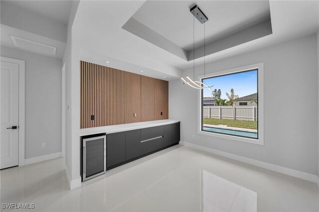 unfurnished dining area with a raised ceiling and an inviting chandelier