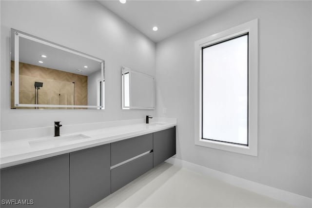 full bathroom featuring double vanity, recessed lighting, a sink, and tiled shower