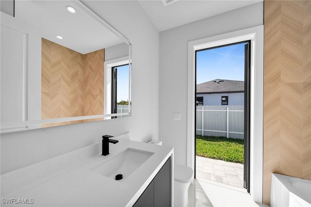 bathroom with vanity, toilet, and recessed lighting