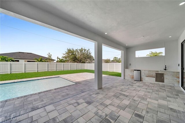 view of patio / terrace featuring an outdoor kitchen and a fenced in pool