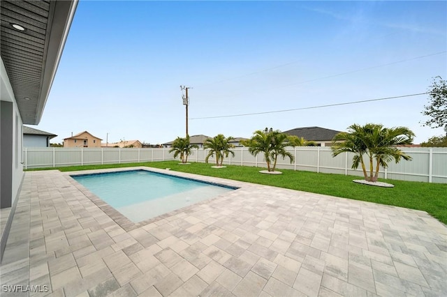 view of pool with a patio and a lawn