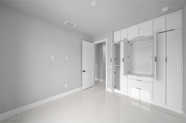 unfurnished bedroom with light tile patterned floors, baseboards, and visible vents