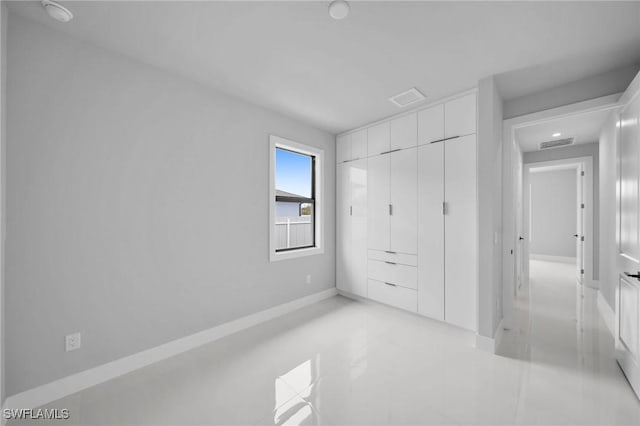 unfurnished bedroom featuring a closet, visible vents, and baseboards