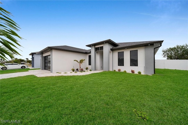 view of front of property featuring a front yard and a garage