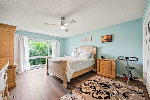 bedroom featuring ceiling fan, a closet, hardwood / wood-style floors, and a textured ceiling